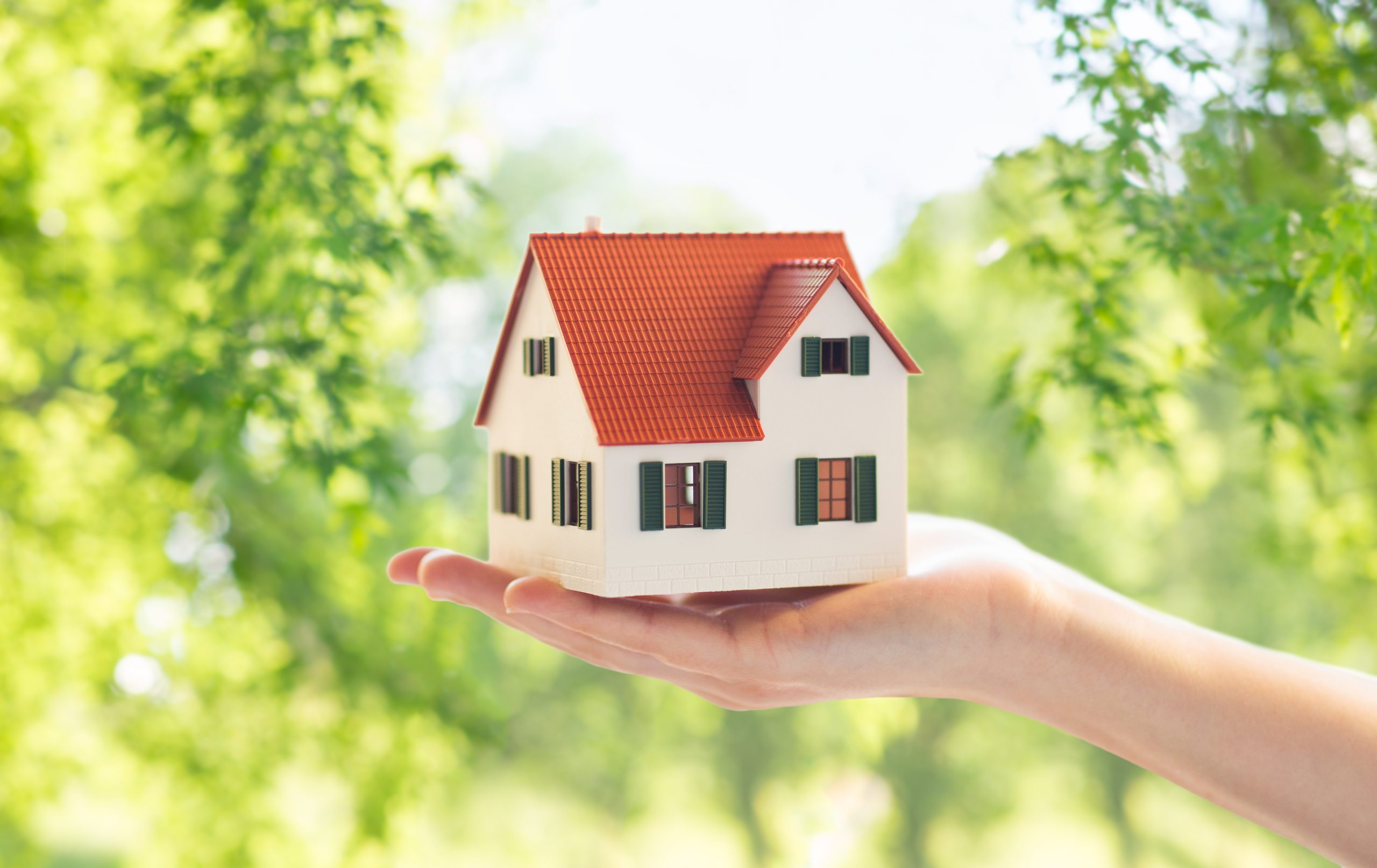 Hand holding a model house, representing getting an EPC before a property is marketed